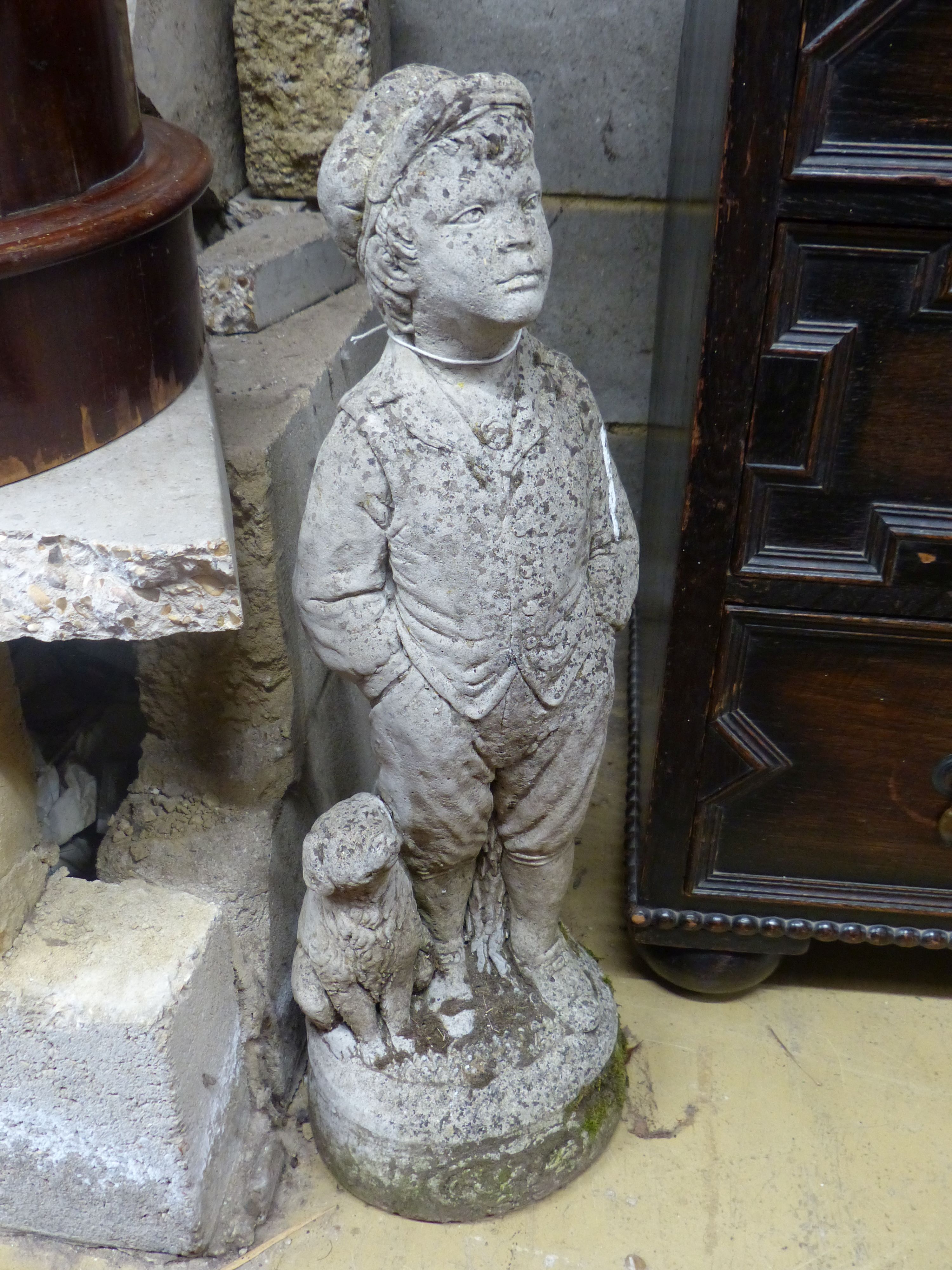 A reconstituted stone garden ornament of a boy with dog, height 69cm